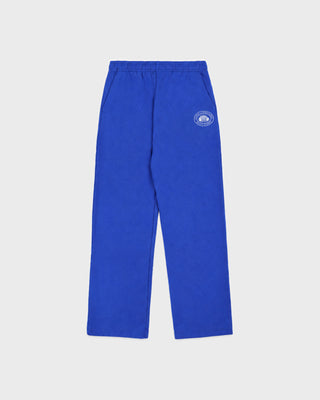 A pair of royal blue sweatpants with an elastic waistband and a small circular logo on the upper left leg, displayed against a light gray background.