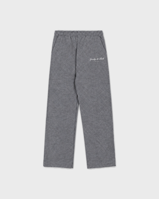 A person in an oversized LuxeFleece sweatshirt, Blakely Signature NY Wide Sweatpant, patterned beanie, and slippers.