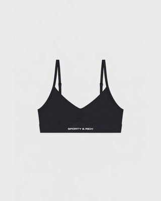 Black sports bra with thin straps on a light gray background