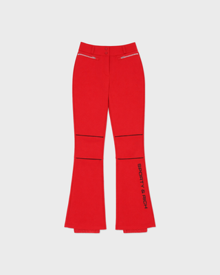 Red flare pants with black seam detailing and vertical 'SPORTY & RICH' text on one leg, shown flat against a light gray background.