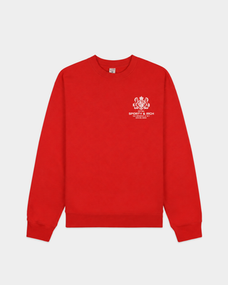 The Emmett Sr Hotel Crewneck - Ruby is a red crewneck sweatshirt inspired by vintage styles, featuring “Sporty & Rich” white logo and text on the left chest area.