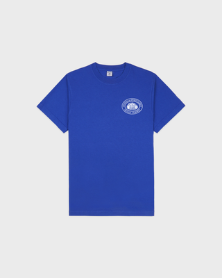 A royal blue short-sleeve crewneck t-shirt with a small white circular graphic printed on the left chest, displayed flat against a light gray background.