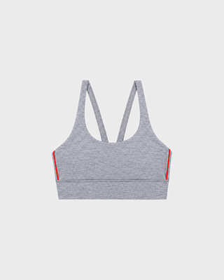 Flor Bold Logo Active Bra in medium heather gray with thin red side stripes and a racerback design.