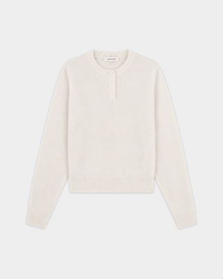 The Iba S Logo Cashmere Henley in Off White features long sleeves, ribbed cuffs and hem, and a three-button placket at the collar. Crafted from a luxurious cashmere-wool blend, this sweater offers both warmth and timeless style.