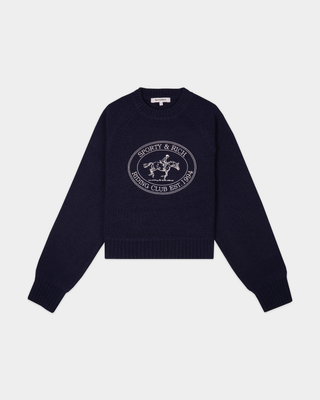 The Joconde Riding Club Knitted Boxy Sweater in Dark Navy features a modern, relaxed fit with a boxy silhouette and showcases the Sporty & Rich Riding Club Est. 1994 lettering and horse logo on the chest.