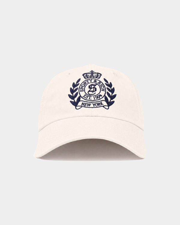 Introducing the Maeve NY Crest Hat in Off White, featuring a navy embroidered crest logo and “Sporty & Rich New York” on the front. This Sporty & Rich hat offers an adjustable back closure for a perfect fit and channels a timeless, vintage-inspired look.