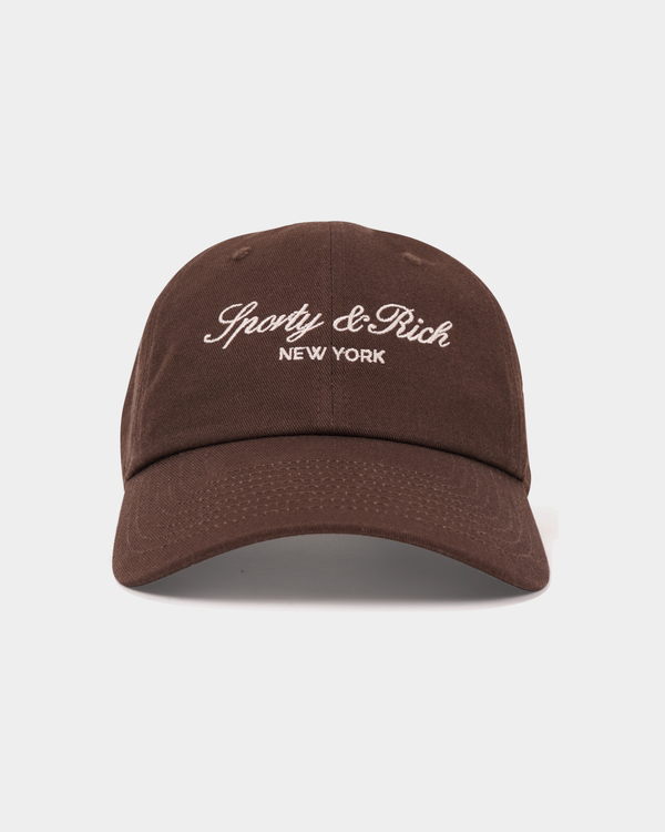 Maeve Vendome Script Hat - Chocolate: brown unstructured baseball cap with white Sporty & Rich NEW YORK embroidery.