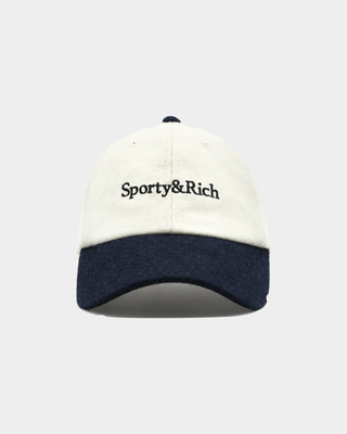 The Marcus Serif Logo Wool Hat in Off White/Dark Navy is a premium wool baseball cap designed for cold-weather comfort, featuring Sporty&Rich embroidery on the front and an adjustable back closure, displayed against a plain background.