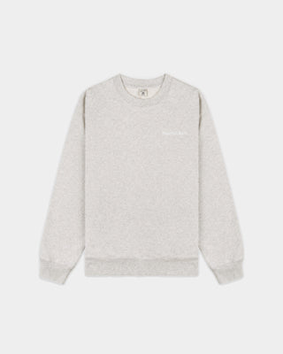 The Eeva Serif Logo Embroidered Crewneck in Heather Gray features a classic crewneck design with long sleeves and subtle white embroidered text on the left chest, making it perfect for fans of vintage-style sweatshirts.