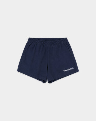 The Lucy Serif Logo Embroidered Disco Short in Dark Navy features an elastic waistband and Sporty & Rich text embroidered on the front left side, making these cotton lounge shorts perfect for a relaxed yet sporty look.