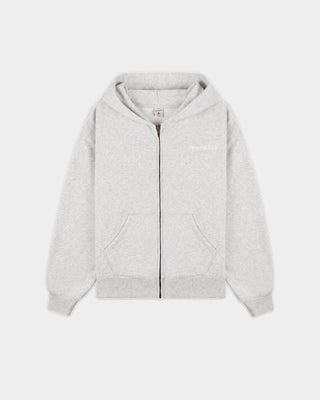 The Emaro Serif Logo Embroidered Zip Hoodie in Heather Gray is laid flat, showcasing its light gray color, zip-up front, front pockets, and a small white embroidered logo on the left chest. This super soft hoodie offers a relaxed fit for ultimate comfort.