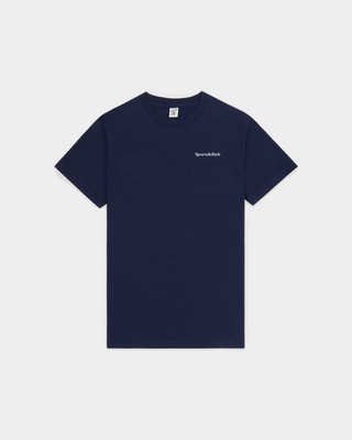 The Fema Serif Logo T-shirt in Dark Navy features a short-sleeve, unisex design with text on the left chest, crafted from 100% cotton and shown laid flat on a white background. This Sporty & Rich tee offers both comfort and timeless style for any wardrobe.