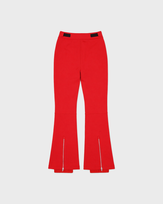 Red flare pants with black seam detailing and vertical 'SPORTY & RICH' text on one leg, shown flat against a light gray background.
