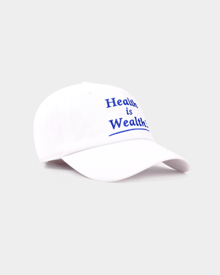 Maeve Health is Wealth Hat - White: a vintage baseball cap with an adjustable back and blue embroidered text.