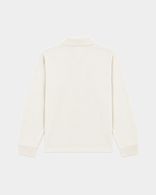 Introducing the Perry Riding Club Longsleeve Pique Polo in Off White—a cream-colored, oversized long-sleeve polo shirt made from 100% cotton piqué. It features a small chest pocket detailed with a blue bear and text logo patch, combining comfort with playful charm.