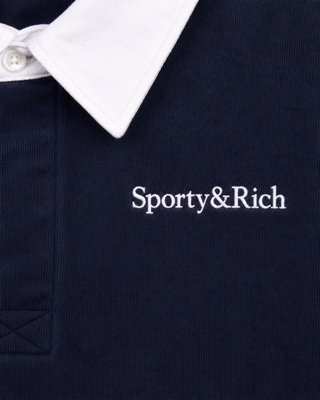 Evin Serif Logo Embroidered Polo in Dark Navy/White, featuring a vintage varsity-inspired cropped boxy fit, contrast white collar, and Sporty & Rich text embroidered on the left chest; displayed flat-lay on a white background.