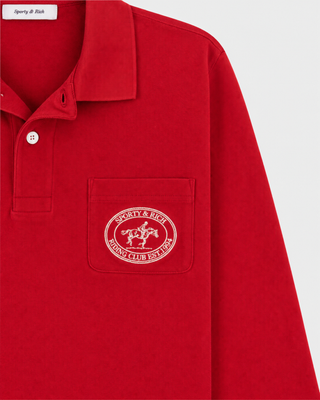 Perry Riding Club Longsleeve Pique Polo in Ruby features a collar and front pocket adorned with a circular white emblem, crafted from soft cotton piqué for enhanced comfort.