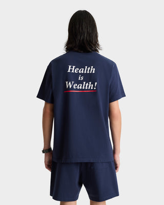 Person wearing a navy Health is Wealth! shirt paired with the Serif Logo Gym Short in Navy/White, featuring a comfortable drawstring waistband.
