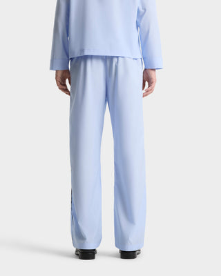 Person shown from the back in Vendome Pyjama Pants - Ciel/Navy with an elastic waistband, paired with a matching long-sleeve shirt against a white background.
