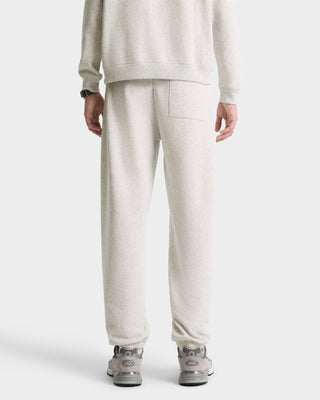 A person is shown from the back wearing California Emblem Soft Sweatpant in Heather Gray/Navy with a matching sweatshirt and gray sneakers. Made in Portugal.