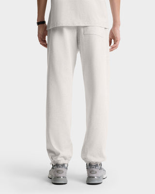 Person wearing NY Health Club Sweatpant - Heather Gray/Navy, made of 100% cotton, shown from the back with gray sneakers against a white background. Made in Portugal.