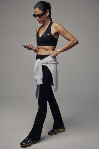Beck Bold Logo Flared Legging - Black features a high-waisted, flared leg silhouette crafted from technical stretch fabric, shown on a plain white background.