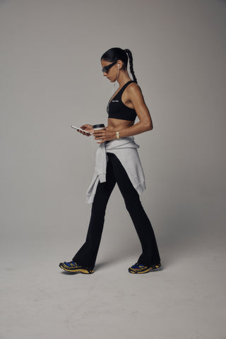 Beck Bold Logo Flared Legging - Black features a high-waisted, flared leg silhouette crafted from technical stretch fabric, shown on a plain white background.