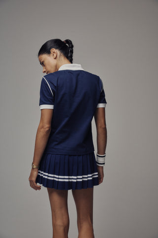 Ally Serif Logo Pleated Skirt in Dark Navy/White, featuring white stripes, a Sporty & Rich logo on the elastic waistband, and built-in shorts for added comfort.