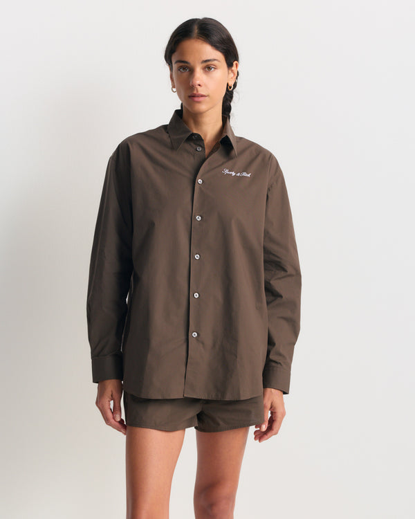 Cora Signature Logo BD Shirt in chocolate garment-dyed cotton with white cursive logo embroidery on the chest.