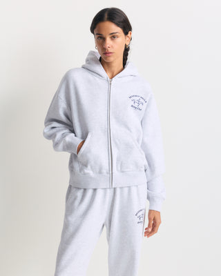 Eliana BH Riding Club Zip Hoodie in heather gray with a navy blue chest graphic.