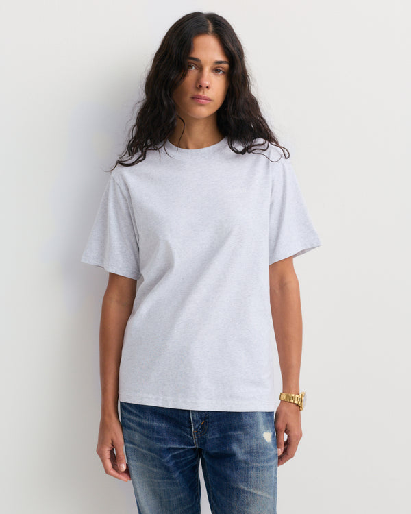 Fema Serif Logo Tshirt - Heather Gray: a unisex short-sleeve tee in light heather gray, made from 100% cotton, featuring small white serif logo text on the left chest, shown against a plain background.