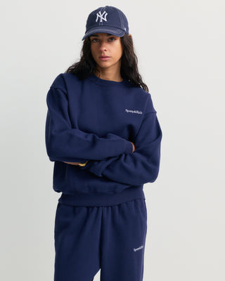 Dark navy Eeva Serif Logo Embroidered Crewneck featuring embroidered text on the upper left chest, laid flat on a white background.