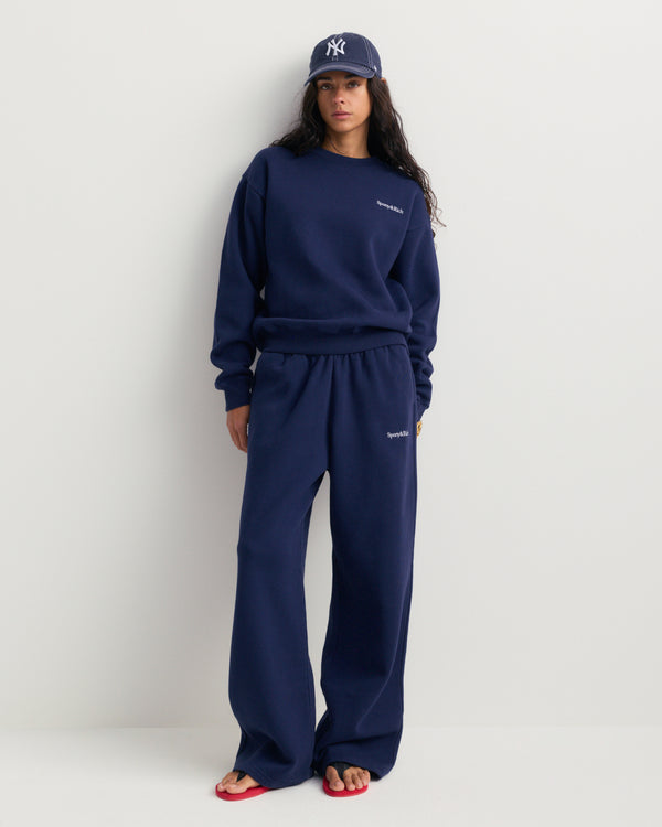 Besma Serif Logo Embroidered Baggy Sweatpant in dark navy, featuring an oversized fit with an elastic waistband and side pockets, laid flat on a white background.