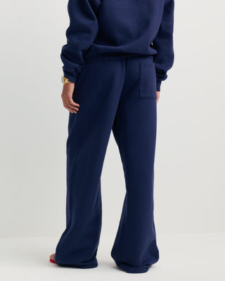 Besma Serif Logo Embroidered Baggy Sweatpant in dark navy, featuring an oversized fit with an elastic waistband and side pockets, laid flat on a white background.