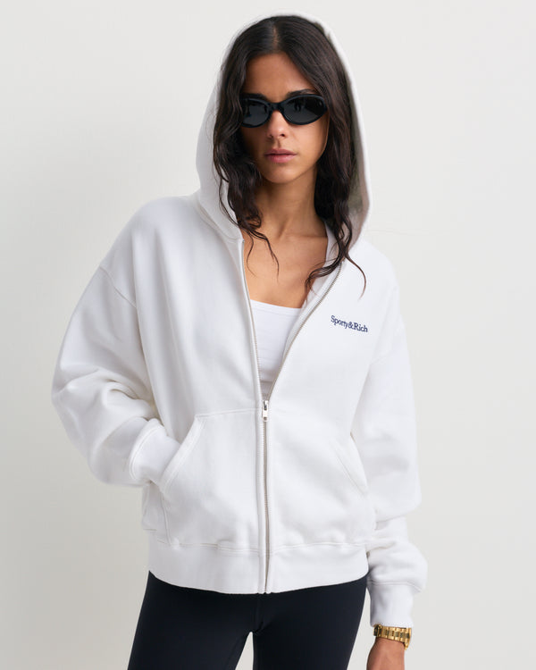 Emaro Serif Logo Embroidered Zip Hoodie in white, featuring a small embroidered logo on the left chest, displayed on a plain background.