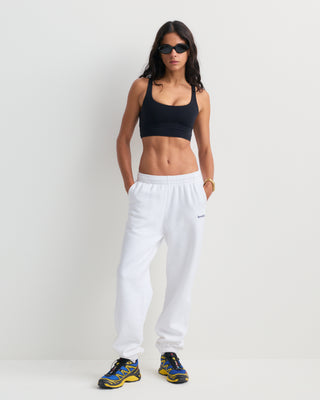 The Brianno Serif Logo Embroidered Jogger in White features elastic cuffs and waistband, front pockets, and a small embroidered Sporty & Rich logo on the left hip, offering a classic jogger fit inspired by their iconic sweatpants.