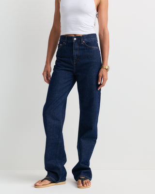 Loose Jean - One Wash, featuring a dark blue wash, high-rise fit, straight-leg silhouette, front pockets, belt loops, and a button closure, shown laid flat on a white background.