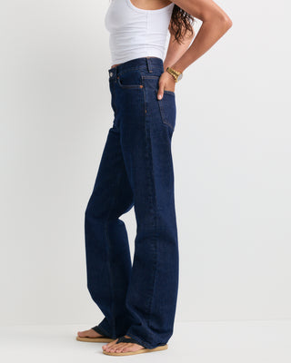Loose Jean - One Wash, featuring a dark blue wash, high-rise fit, straight-leg silhouette, front pockets, belt loops, and a button closure, shown laid flat on a white background.