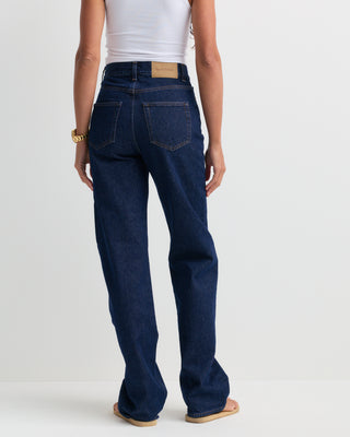 Loose Jean - One Wash, featuring a dark blue wash, high-rise fit, straight-leg silhouette, front pockets, belt loops, and a button closure, shown laid flat on a white background.