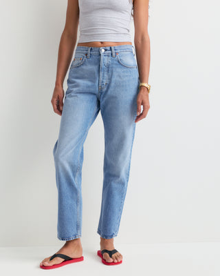 The Straight Jean - Light Wash is a pair of light blue, high-rise denim jeans featuring five pockets and a slightly faded finish. Expertly crafted in Italy, these jeans are laid flat to showcase their classic straight-leg silhouette.