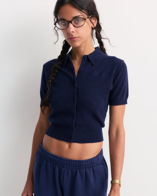 Jannie Signature Logo Cashmere SS Cardigan in Dark Navy—this cropped, short-sleeve knit features a button front, classic collar, and subtle signature embroidery on the left chest for a modern touch.