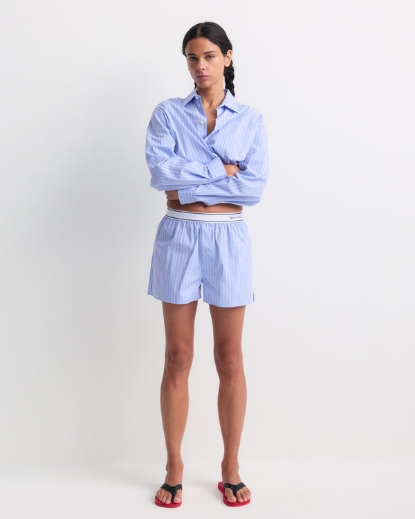 Beth Serif Logo Boxer - Blue Striped, crafted from breathable cotton with light blue pinstripes, features a relaxed fit and a white waistband labeled Sporty & Rich, displayed on a plain background.