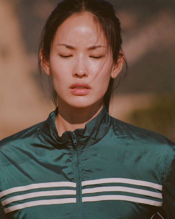 Person wearing a green jacket with white stripes in an outdoor setting