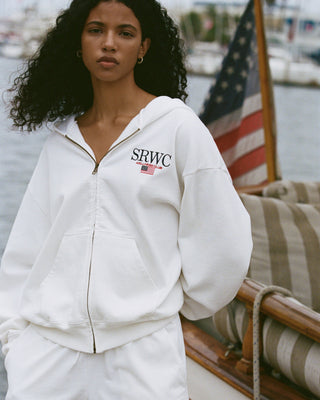 Person wearing a white hoodie with 'SRWC' logo on a boat