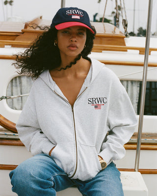Person wearing a gray hoodie and cap with 'SRWC' branding on a boat.
