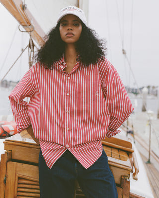 Woman wearing a red and white striped shirt and white cap on a boat