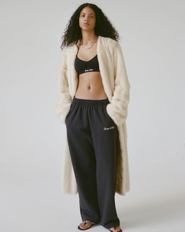 Woman wearing a cream cardigan and black pants with text on a white background