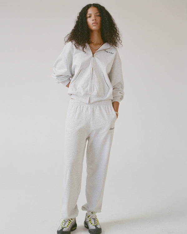 Person wearing a gray tracksuit on a white background