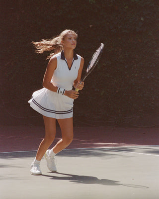 Woman playing tennis on a court with a racket