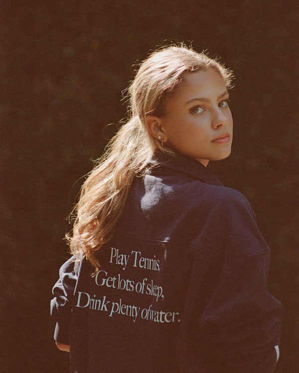 Person wearing a jacket with motivational text on the back against a dark background